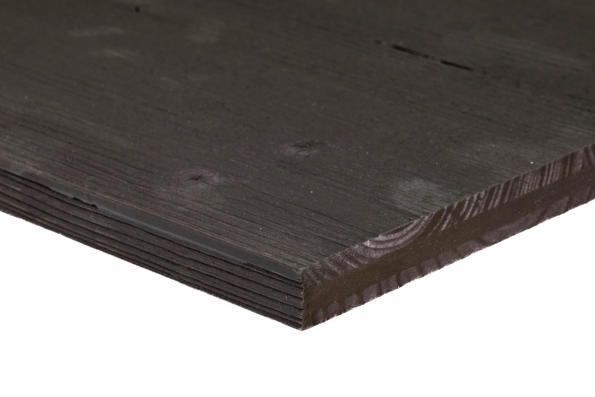 Close-up of a dark black reclaimed barn wood panel edge showing natural grain lines, character knots, and layered construction.