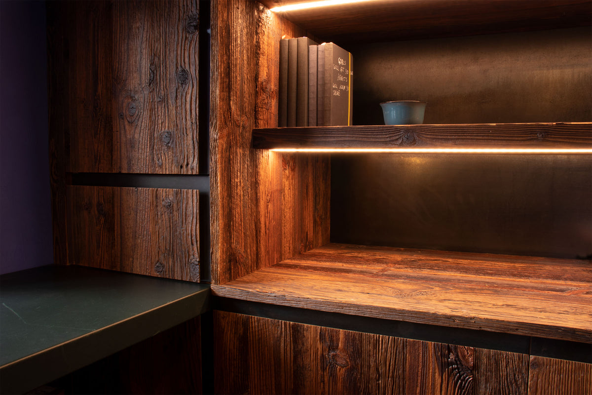 Engineered barn-wood office with matching worktop, shelves, reclaimed wood doors, steel handles, leather-topped table, and integrated LED lighting