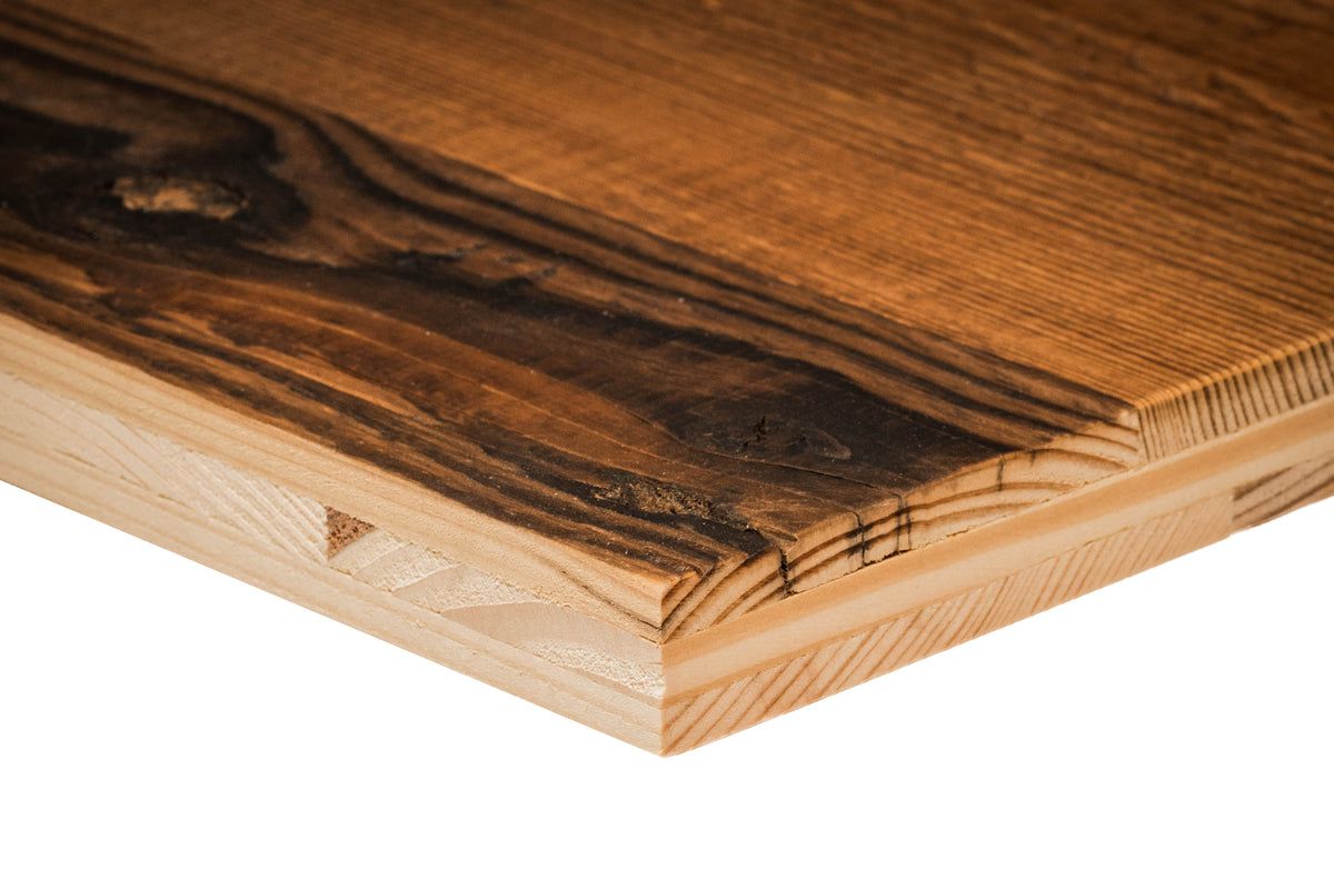 Close-up of a golden-brown reclaimed barn wood panel edge featuring prominent knots and a weathered grain surface.