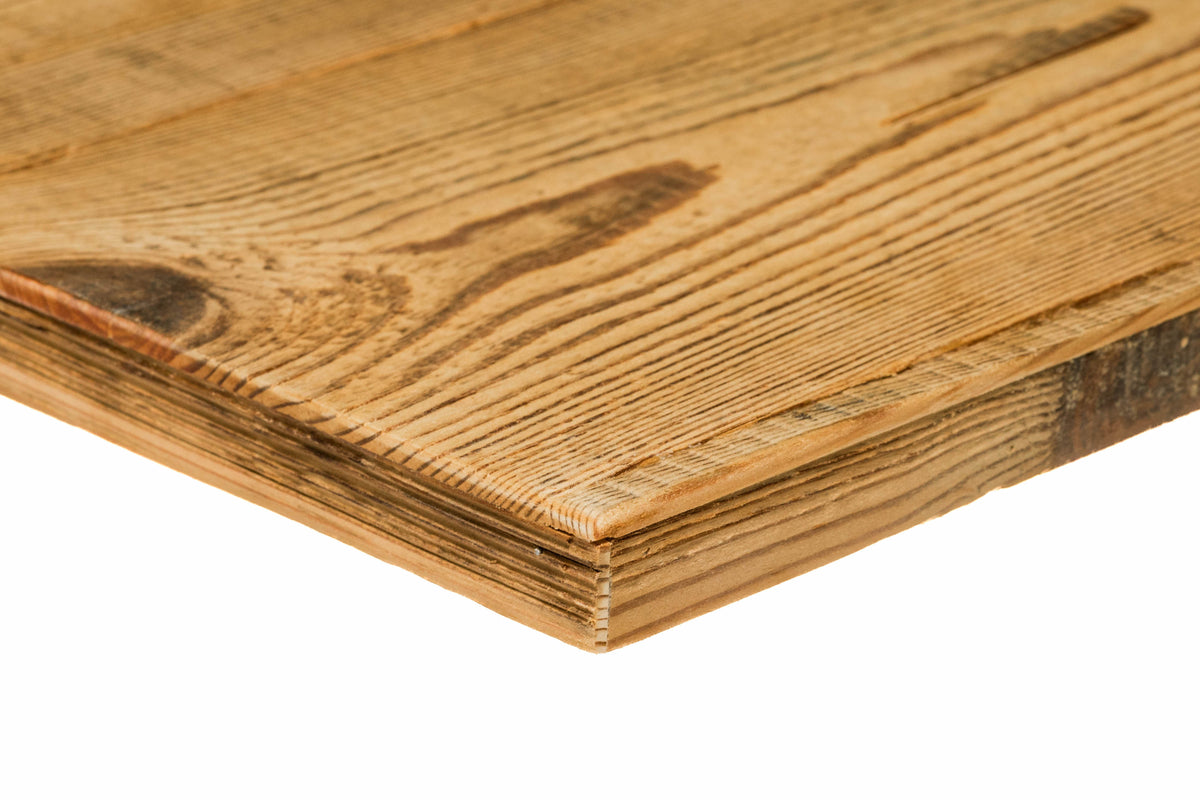 Close-up of a light honey-brown reclaimed barn wood panel edge with warm tones and visible aged grain texture.