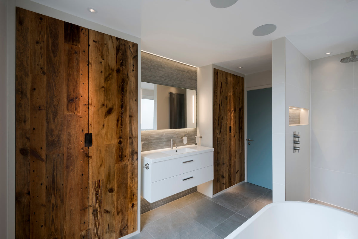Reclaimed barn wood bathroom cabinetry showcasing solid real wood with natural grain, knots and character alongside a contemporary vanity with steel cutout handles